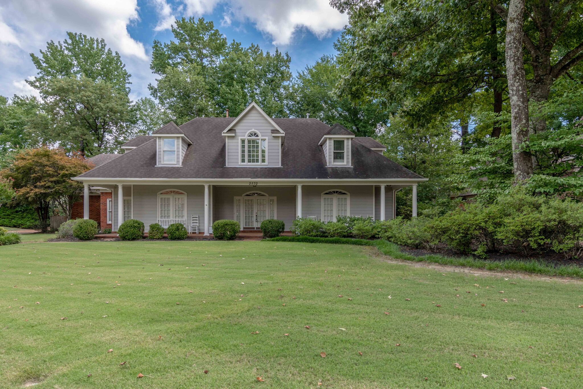 grey farmhouse style home with large front porch and white columns cordova tennessee real estate harbur realty